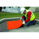 Man in hardhat and safety vest placing Sellars 24 x 24 drain seal over drain